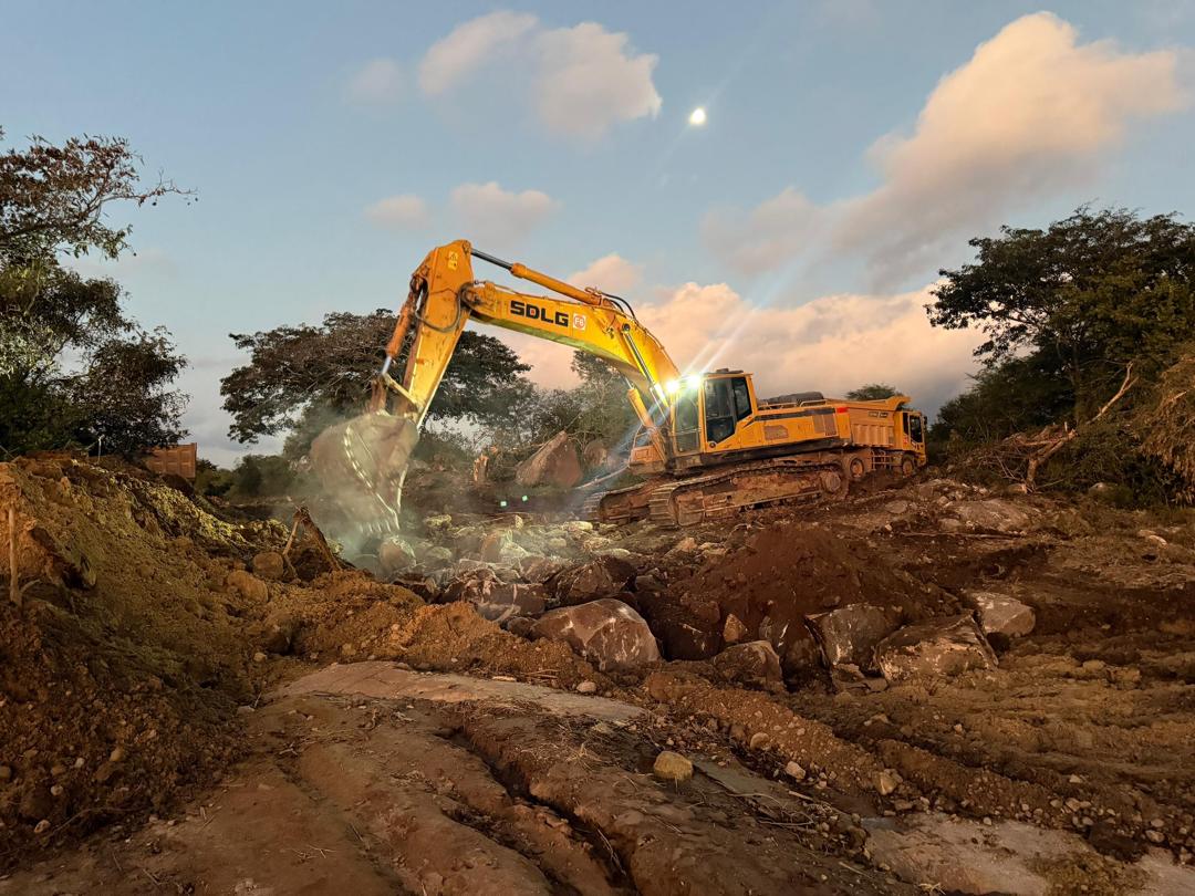 SDLG excavator breaking rock at sunset